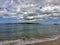 Lava Rock and Coral with Spray of crashing wave in tide pools at Maluaka Beach and Kihei Maui with sky and clouds