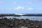 The lava rock shoreline and sea wall of Hilo Bay, creating a large tide pool, with the tide coming in, Hilo, Hawaii