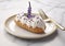 Lavender cream eclair on plate in fine dining restaurant.Macro.AI Generative