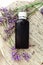 Lavender essential oil bottle on white wooden rustic board with fresh lavender flowers. Aromatherapy treatment, natural organic