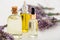 Lavender essential oil bottles, serum, dropper on white wooden rustic table fresh lavender flowers. Aromatherapy treatment,