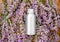 Lavender essential oil metal silver bottle on fresh lavender flowers. Flat lay apothecary herbs for aromatherapy treatment.