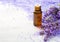 Lavender essential oil, sprigs of lavender and mineral bath salts on the wooden table. Selective focus