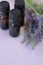 Lavender essential oil.Three brown glass pharmacy jars with lavender oil and lavender flowers on a lilac background