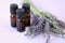 Lavender essential oil.Three brown glass pharmacy jars with lavender oil and lavender flowers on a lilac background