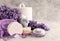 Lavender flowers, candle in the marble candlestick, aroma bath salt, other hygiene supplies and towels on marble background