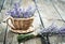 Lavender flowers in a wicker vase on old boards.