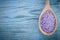 Lavender mineral sea salt in wooden spoon on wood board healthca