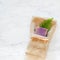Lavender Scented Soap with Tan Washcloth and Green Fern Frond on Bathroom Gray and White Marble Surface with room or space for cop