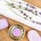 Lavender soap, scented candle, dried lavender flowers and a towel on a wooden background