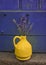 Lavender in a yellow vase on a background of purple shabby door