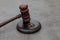 Law theme. Judge gavel wedding rings on concrete stone grey background. Divorce proceedings. Mallet of judge deciding on