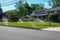 Lawn irrigation system spraying water from several nozzles onto a green grass lawn in front of a house