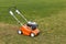 Lawn mover on green grass on background of field or garden. Machine for cutting lawns. Grass-cutter outdoors, special equipment