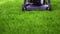 Lawn mower cutting green grass