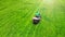 Lawn mower with gardener. Grass cutting. Aerial from drone.