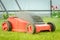 Lawn mower on the tonsured lawn/red lawn mower on the tonsured lawn. Selective focus