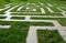 Lawn in the park with gray tiles arranged in the shape of a large maze which is for children. You can`t get lost in it and finding