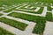 Lawn in the park with gray tiles arranged in the shape of a large maze which is for children. You can`t get lost in it and finding