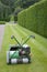 Lawnmower against of background of hedge in English garden