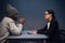 A lawyer girl with glasses and a young black guy communicate in the interrogation room about the grounds for his