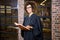 Lawyer standing near library with law book