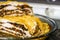 Layered Baked Meat Pie with mushrooms and vegetables topped with melted cheese is on the table in glass tray