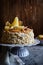 Layered cake with caramel glaze, decorated with almond slices, pears, spun sugar decorations and cinnamon sticks