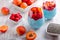 Layered chia seeds pudding with apricot, raspberry in glasses on white wooden background. Mousse with chia seeds