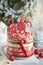 Layered Christmas gingerbread cake decorated with red Lolli pops, colored confetti on white cake stand, Christmas balls, fir