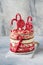 Layered Christmas gingerbread cake decorated with red Lolli pops, colored confetti on white cake stand, Christmas balls, fir