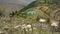 A layered cinematic shot of Himalayan Meadows with farmlands, and a traditional mud home in the background. Uttarakhand India