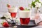 Layered dessert in glass with vanilla panna cotta and jelly with strawberries