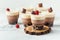 Layered dessert Trifles in a transparent glass. Sponge biscuit and three chocolate mousse layers. Chocolate souffle trifle cake
