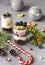 Layered desserts with vanilla and chocolate cake, whipped cream and blackberries in mason jars.