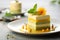 Layered matcha biscuit cake with pistachio and mango souffle on plate on restaurant table. Healthy sweet food concept. Matcha