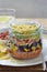 Layered Mexican sandwich jar with black beans, lettuce, cheese, red peppers, lettuce and tortilla chips