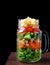 Layered salad with cheese, kale, carrot, chicken, cucumbers and cherry tomatoes