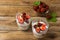 Layered strawberries cream cheese dessert on wooden background