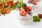 Layered strawberry dessert with yogurt on white background