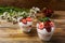 Layered strawberry yogurt dessert on wooden background