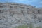 Layered white, gray hill in New Mexico under cloudy blue sky