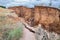 Layers of earth with cracks on trail path due to landslides of the soil.