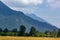 layers of mountains and hills rise up behind meadow