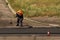 Laying asphalt by workers. Road construction. Modern technology of laying a highway with a solid surface. People work at a