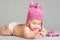 Laying baby in stripy pink cap