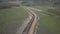 Laying gas pipeline among green hills. Large high-pressure steel pipes prepared for immersion in the excavated trench. Land works