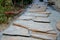 Laying porphyry of large flat stones. the paving is laid in some gravel, the joints are then filled with pebbles. garden nature pa