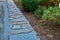 Laying porphyry of large flat stones. the paving is laid in some gravel, the joints are then filled with pebbles. garden nature pa