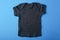 Layout Black Children`s T-shirt on a blue background.Mockup .Flat lay